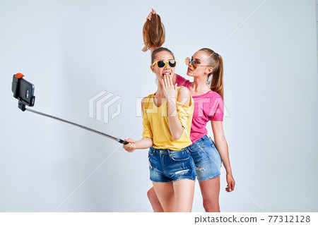 portrait of happy teenagers taking selfie together isolated on whitePortrait of happy teenagers in summer clothes, sunglasses taking selfie together isolated on white. portrait of happy teenagers taking selfie together isolated on whitePortrait of happy teenagers in summer clothes, sunglasses taking selfie together isolated on white. 77312128