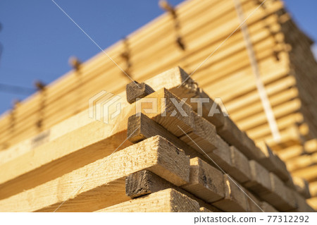 Storage of piles of wooden boards on the sawmill. Boards are stacked in a carpentry shop. Sawing drying and marketing of wood. Pine lumber for furniture production, construction. Lumber Industry. Storage of piles of wooden boards on the sawmill. Boards are stacked in a carpentry shop. Sawing drying and marketing of wood. Pine lumber for furniture production, construction. Lumber Industry. 77312292