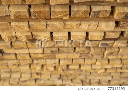 Storage of piles of wooden boards on the sawmill. Boards are stacked in a carpentry shop. Sawing drying and marketing of wood. Pine lumber for furniture production, construction. Lumber Industry. Storage of piles of wooden boards on the sawmill. Boards are stacked in a carpentry shop. Sawing drying and marketing of wood. Pine lumber for furniture production, construction. Lumber Industry. 77312293