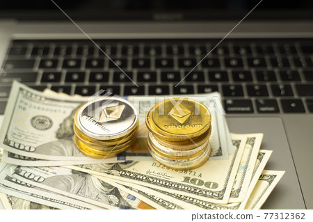 Ethereum coins on a dollars and on a laptop. Trading on the cryptocurrency exchange. Cryptocurrency Stock Market Concept. Mining or blockchain technology. Business concept. Ethereum coins on a dollars and on a laptop. Trading on the cryptocurrency exchange. Cryptocurrency Stock Market Concept. Mining or blockchain technology. Business concept. 77312362