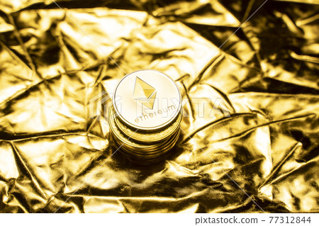 Gold ethereum coins on a golden background. Trading on the cryptocurrency exchange. Cryptocurrency Stock Market Concept. Virtual money concept. Mining or blockchain technology. Business concept. 77312844