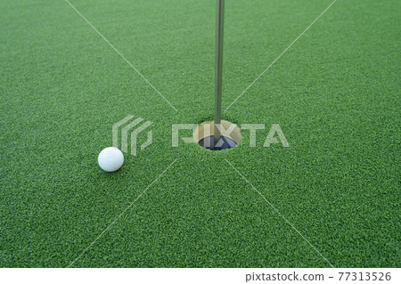 Golf ball hole with green grass field in golf court. Outdoor sport and recreation activity. Lifestyle Golf ball hole with green grass field in golf court. Outdoor sport and recreation activity. Lifestyle 77313526