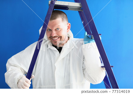 Portrait of smiling male worker in white suit with stepladder Portrait of smiling male worker in white suit with stepladder 77314019