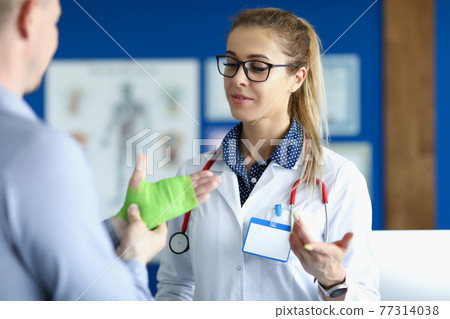 Traumatologist examines patient hand. Hand injuries and sprains Traumatologist examines patient hand. Hand injuries and sprains 77314038