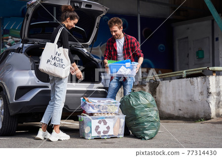 Family taking the waste boxes out of the trunk 77314430