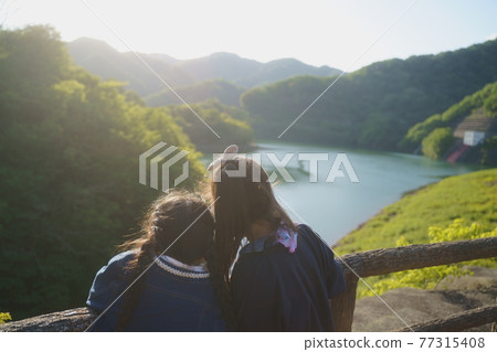 Sisters looking at the lake 77315408