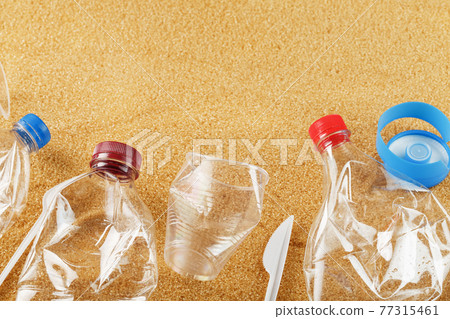 Plastic trash on a sandy beach with Trash from plastic bottles on a sandy beach with free space. Plastic trash on a sandy beach with Trash from plastic bottles on a sandy beach with free space. 77315461