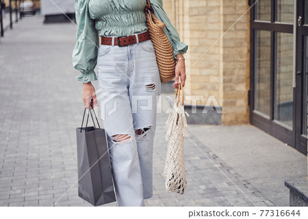 Day time shot of woman with shopping bags 77316644