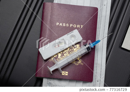 COVID-19, travel and lockdown concept,Passport with Covid-19 rapid test and syringe for vaccination Coronavirus. Traveling requirement flying 77316729