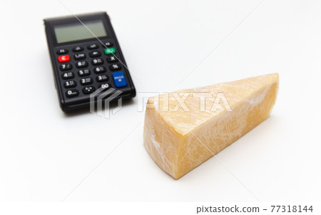 A piece of cheese wrapped in polyethylene, cash register. Cheese is triangular on the the white background. Plastic film A piece of cheese wrapped in polyethylene, cash register. Cheese is triangular on the the white background. Plastic film 77318144