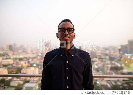 Portrait of handsome African businessman outdoors at rooftop smiling Portrait of handsome African businessman outdoors at rooftop smiling 77318146
