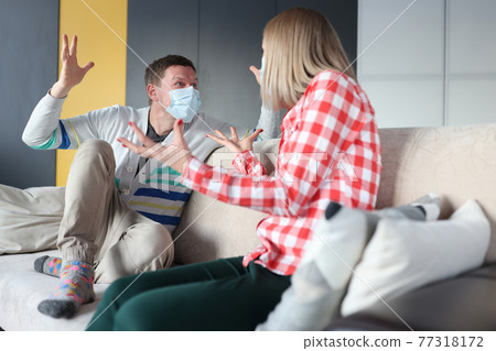 Man and woman in protective masks are fighting at home. Man and woman in protective masks are fighting at home. 77318172