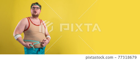 Funny fat man in sportswear measures the volume. gym promotion poster Funny fat man in sportswear measures the volume. gym promotion poster 77318679