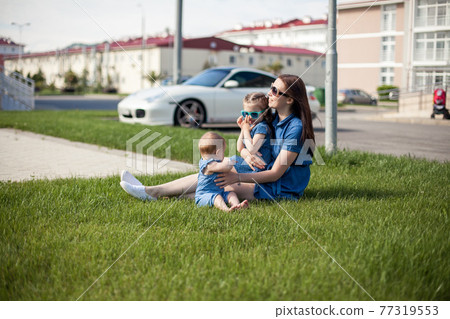 young mother with daughters dressed in denim dresses. Family look. Happy family young mother with daughters dressed in denim dresses. Family look. Happy family 77319553