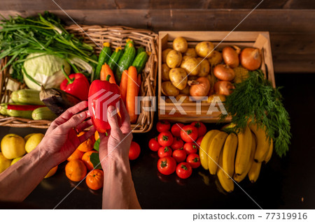 Assortment of fresh vegetables and fruits on wooden table Assortment of fresh vegetables and fruits on wooden table 77319916