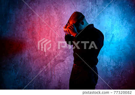 Closeup of young man wearing virtual reality goggles in modern studio. Smartphone using with VR headset. 77320082