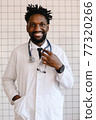 close-up portrait of black doctor smiling and looking at camera 77320266