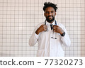 close-up portrait of black doctor smiling and looking at camera 77320273