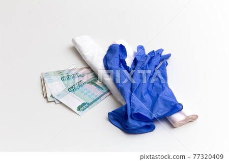 Plastic bags and blue gloves are on the ruble banknotes on the white background. Package 77320409
