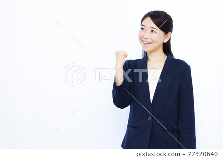 Business woman in her thirties doing a guts pose Business woman in her thirties doing a guts pose 77320640
