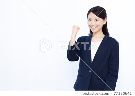 Business woman in her thirties doing a guts pose Business woman in her thirties doing a guts pose 77320641