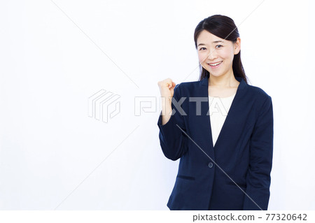 Business woman in her thirties doing a guts pose Business woman in her thirties doing a guts pose 77320642