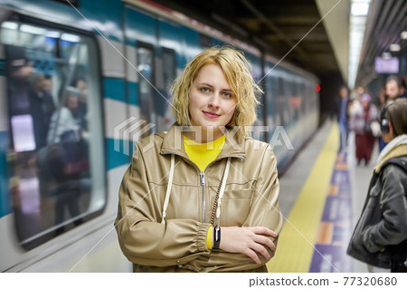 Subway station in Istanbul, Turkey, young Caucasian woman stands on platform while waiting for train. Subway station in Istanbul, Turkey, young Caucasian woman stands on platform while waiting for train. 77320680