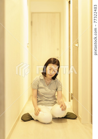 疲憊的中年婦女坐在走廊裡 77322483