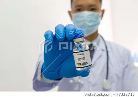 Doctor or laborant holding COVID-19 vaccine tube Or coronavirus vaccine. Coronavirus Vaccine concept. Doctor or laborant holding COVID-19 vaccine tube Or coronavirus vaccine. Coronavirus Vaccine concept. 77322715