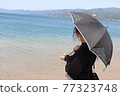 Woman looking at the sea 77323748