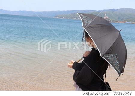 Woman looking at the sea 77323748