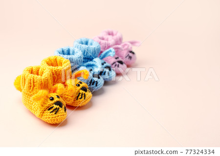Baby shower, gender party. Boy, girl, queer, neatral. Three pairs of baby socks, booties with funny bunny decor, celebration concept when the gender of the child becomes known 77324334