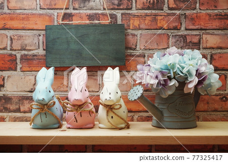 Empty wooden hanging on old brick wall with Easter rabbit on wooden shelve Empty wooden hanging on old brick wall with Easter rabbit on wooden shelve 77325417