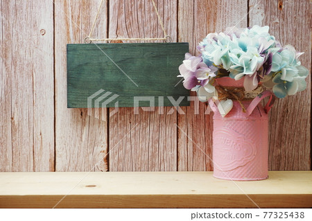Empty wooden hanging on wooden background with home decor on wooden shelve Empty wooden hanging on wooden background with home decor on wooden shelve 77325438