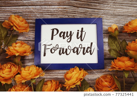 Pay it forward typography text with flower decoation on wooden background Pay it forward typography text with flower decoation on wooden background 77325441