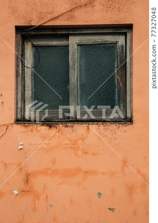 Old window with orange wall 77327048