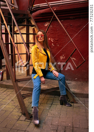 Thr Girl in a yellow jacket in a red yard Thr Girl in a yellow jacket in a red yard 77328281