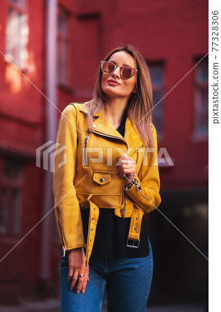 Thr Girl in a yellow jacket in a red yard 77328306