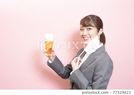 Woman with beer off mask Woman with beer off mask 77329823