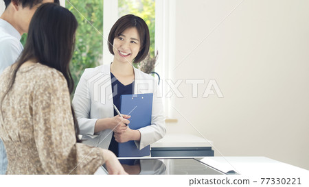 Female person in charge of guiding a couple to a room Model house House maker Finding a room 77330221