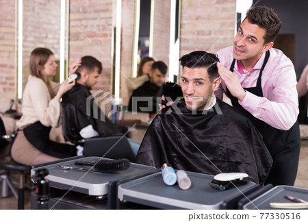 Hairstylist presenting result of his styling to male client Hairstylist presenting result of his styling to male client 77330516