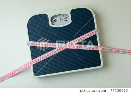 Scales with measuring tape on white background Scales with measuring tape on white background 77330613