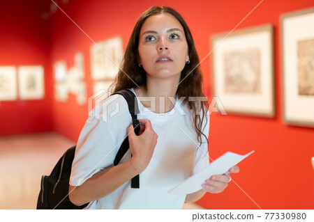 Focused girl visitor, admiring the paintings in the museum 77330980