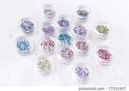 acrylic jars with multicolored glitters for nails on a white background 77332407