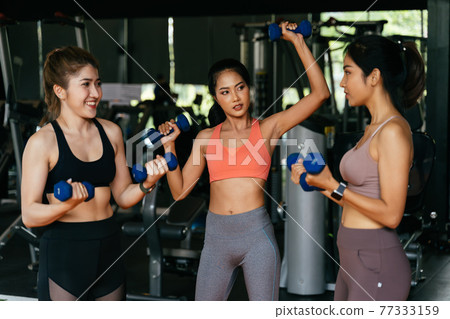 Cheerful diverse group of sportswomen exercising in gym 77333159
