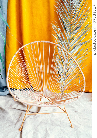 chair on the background of a palm branch. interior in Balinese style. Wooden wicker chair 77333217