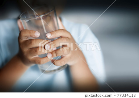 selective focus of child holding empty drinking glass 77334118