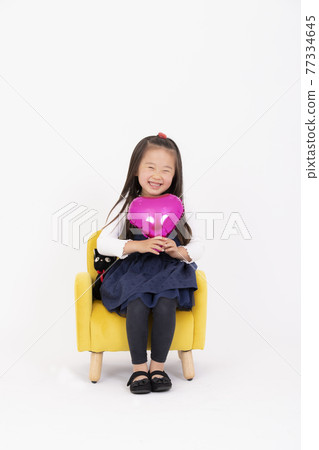 一個微笑的女孩坐在椅子上 一個微笑的女孩坐在椅子上 77334645