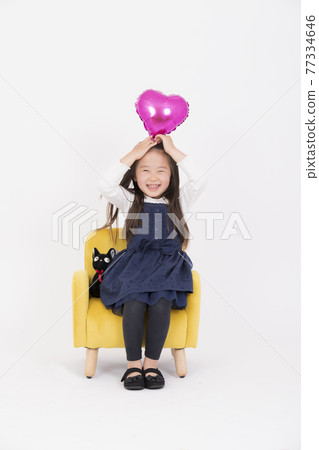 一個微笑的女孩坐在椅子上 一個微笑的女孩坐在椅子上 77334646