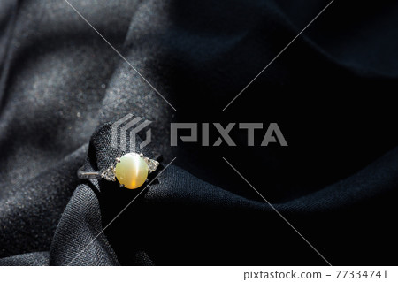 white gold diamond ring isolated on black fabric background white gold diamond ring isolated on black fabric background 77334741